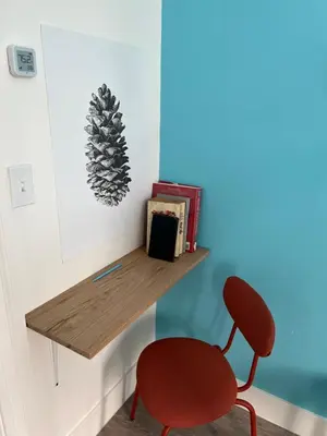 a red chair sitting in a room with a desk at East Harlem Hostel in New York