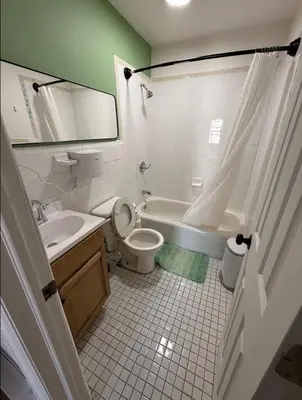 a bathroom with a tub and a toilet and a sink at East Harlem Hostel in New York