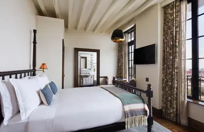 a bedroom with a large bed and a large window at The Ludlow Hotel in New York