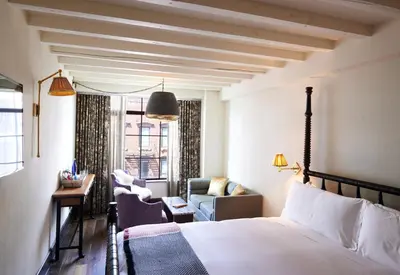 a hotel room with a bed and a chair at The Ludlow Hotel in New York