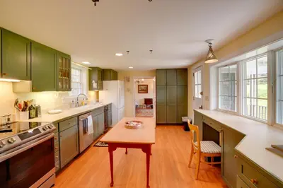 a kitchen with green cabinets and a wooden table at Historic New Lebanon Hideaway on 33 Private Acres! in New Lebanon