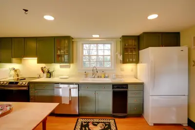 a kitchen with green cabinets and a white refrigerator at Historic New Lebanon Hideaway on 33 Private Acres! in New Lebanon