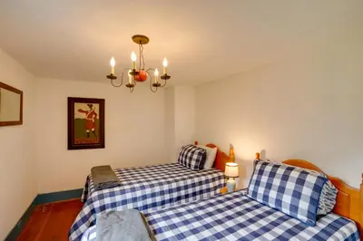 a bedroom with two beds and a chandelier at Historic New Lebanon Hideaway on 33 Private Acres! in New Lebanon