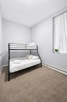 a bedroom with a black bunk bed with a window at Cozy up with me! Longer stays! Free parking in Troy