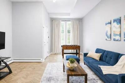 a living room with a blue couch and a table at Cozy up with me! Longer stays! Free parking in Troy