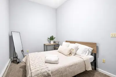 a bedroom with a bed with white sheets and pillows at Cozy up with me! Longer stays! Free parking in Troy