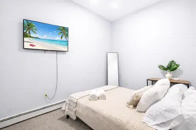 a bedroom with a bed and a tv on the wall at Escape your everyday in your COZY HIDEAWAY Feel right at home Relax recharge & unwind in Troy