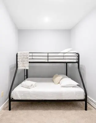 a black bunk bed in a white room at Escape your everyday in your COZY HIDEAWAY Feel right at home Relax recharge & unwind in Troy