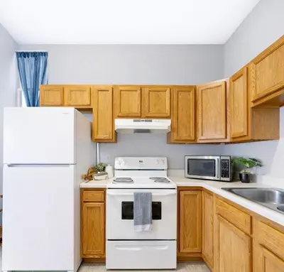 a kitchen with white appliances and wooden cabinets at Escape your everyday in your COZY HIDEAWAY Feel right at home Relax recharge & unwind in Troy