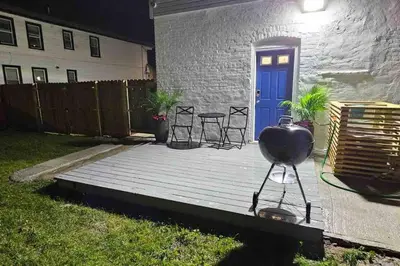 a backyard with a bbq grill on a wooden deck at Two bedrooms with parking & washer/dryer in Schenectady