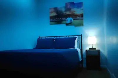 a blue bedroom with a bed and a lamp at Two bedrooms with parking & washer/dryer in Schenectady
