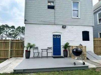 a house with a blue door and chairs and a grill at Two bedrooms with parking & washer/dryer in Schenectady