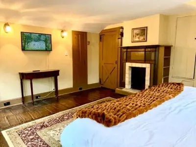 a bedroom with a large bed with a fireplace at INCREDIBLE Northern Westchester Historic Hideaway in South Salem