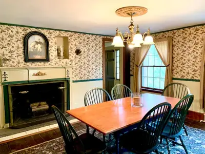 a dining room with a table and chairs and a fireplace at INCREDIBLE Northern Westchester Historic Hideaway in South Salem