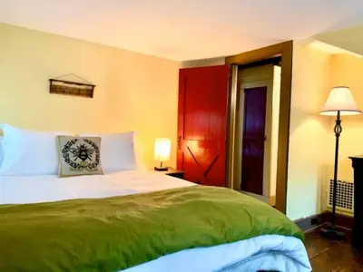 a bedroom with a large bed and a red door at INCREDIBLE Northern Westchester Historic Hideaway in South Salem