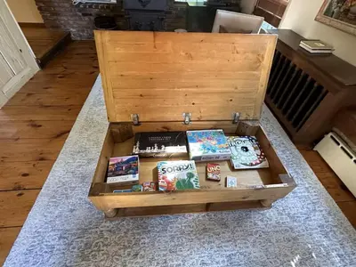 a wooden box filled with books on a rug at INCREDIBLE Northern Westchester Historic Hideaway in South Salem