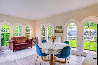 a dining room with a table and blue chairs at Walk to Harbor! Historic Mamaroneck Guest House in Mamaroneck