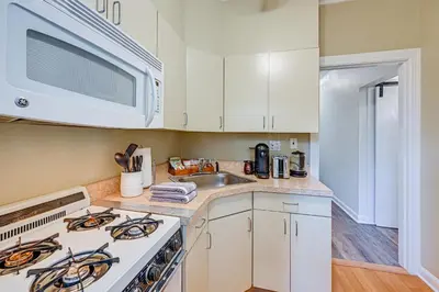 a kitchen with a stove and a sink and a microwave at Walk to Harbor! Historic Mamaroneck Guest House in Mamaroneck