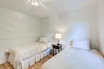a bedroom with two beds and a lamp on a table at Walk to Harbor! Historic Mamaroneck Guest House in Mamaroneck