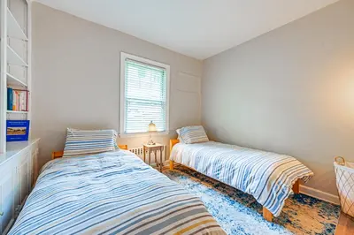 two beds in a small room with a window at Walk to Harbor! Historic Mamaroneck Guest House in Mamaroneck