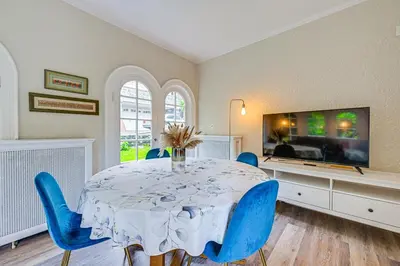 a dining room with a table and blue chairs at Walk to Harbor! Historic Mamaroneck Guest House in Mamaroneck