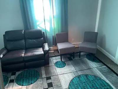 a living room with a leather couch and two chairs at Mo Short Term Rentals in Mount Vernon