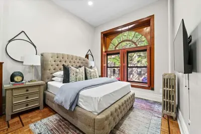 a bedroom with a large bed and a window at Newly Renovated 2BR Haven Walk to Columbia Uni in New York