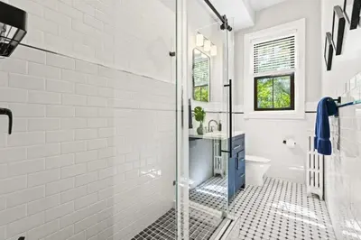 a white bathroom with a shower and a toilet at 3BR Retreat Walkable to Columbia University in New York