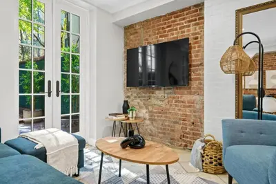 a living room with a brick wall at Newly Renovated 2BR w Rare Private Backyard and BBQ in New York