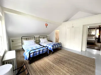 a bedroom with two beds and a rug at Historic Estate - 5 min to Mohawk Mt Ski Resort in Cornwall
