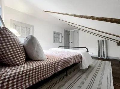 a bedroom with a bed with a checkered blanket at Historic Estate - 5 min to Mohawk Mt Ski Resort in Cornwall