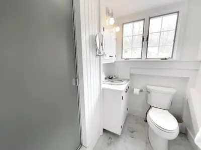 a white bathroom with a toilet and a sink at Historic Estate - 5 min to Mohawk Mt Ski Resort in Cornwall
