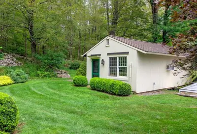 a small white shed in the middle of a yard at Historic Estate - 5 min to Mohawk Mt Ski Resort in Cornwall