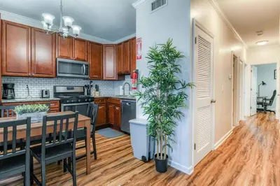 a kitchen with wooden cabinets and a table with a plant at Modern 3BR2BA Apartment Minutes to NYC in Jersey City