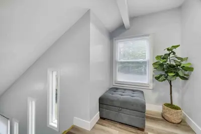 a living room with a gray ottoman and a plant at Cozy, Spacious House *New*InTheCommunity+Fire Pit in Tobyhanna