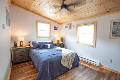 a bedroom with a large bed and two windows at Madison Cabin #2 in Hamilton
