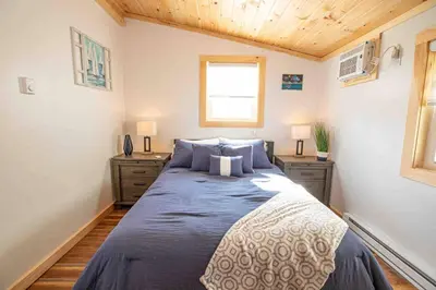 a bedroom with a large bed with blue pillows at Madison Cabin #2 in Hamilton