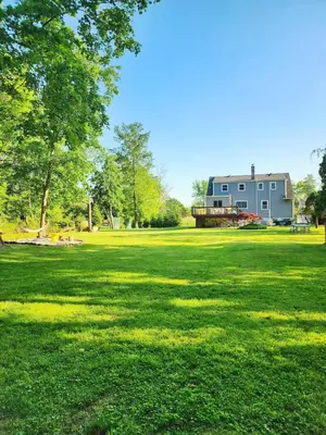 a large grass field with a house in the background at Starlight Guesthouse in West Orange