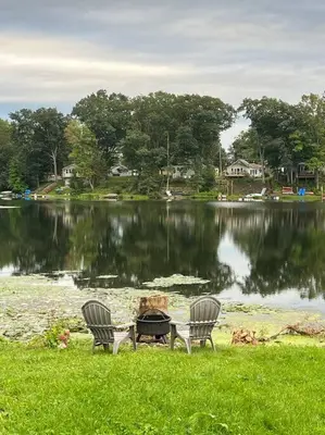 two chairs and a table in front of a lake at Lake View Retreat in Cambridge