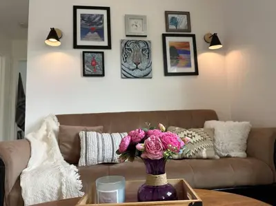 a living room with a couch and a vase of flowers on a table at Lake View Retreat in Cambridge