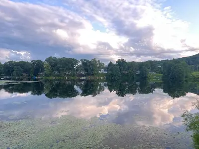 a lake with a reflection of clouds in the water at Lake View Retreat in Cambridge