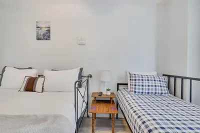 a bedroom with two beds and a side table at Nature’s Haven:4 br/2.5 bath, game room & Fire pit in Tobyhanna
