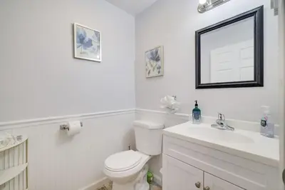 a white bathroom with a toilet and a sink at Nature’s Haven:4 br/2.5 bath, game room & Fire pit in Tobyhanna