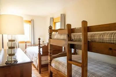 a bedroom with two bunk beds and a lamp at Cozy Cabin in Stratton Mountain & Mount Snow 10min in Stratton