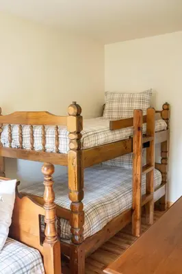 two bunk beds in a room with a table at Cozy Cabin in Stratton Mountain & Mount Snow 10min in Stratton