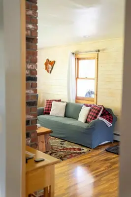 a living room with a blue couch and a window at Cozy Cabin in Stratton Mountain & Mount Snow 10min in Stratton