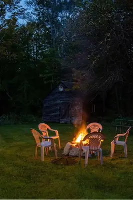 four chairs around a fire pit in a yard at Cozy Cabin in Stratton Mountain & Mount Snow 10min in Stratton