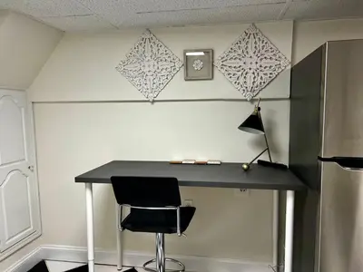 a desk with a chair and a clock on a wall at 6-A Diamond in Yonkers, NY in Yonkers