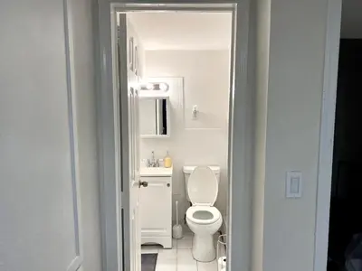 a white bathroom with a toilet and a sink at 6-A Diamond in Yonkers, NY in Yonkers