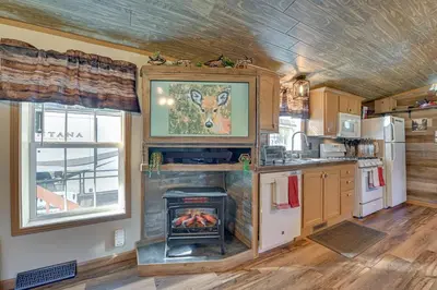 a kitchen with a fireplace in the middle of a room at Northville Cabin with Fire Pit, 4 Mi to Boat Ramp! in Northville